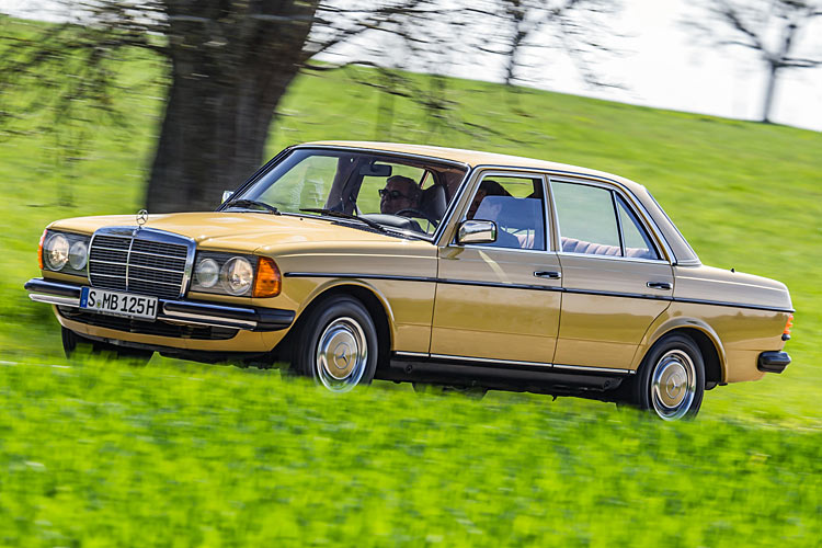 Mercedes W123 Limousine in gelb vor grünem Wiesenhintergrund