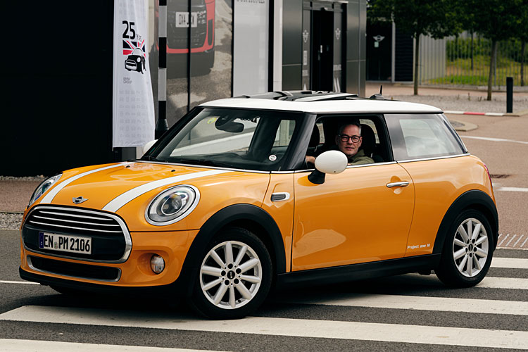 Ein orangefarbener Mini Cooper Diesel fährt im Mini-Werk Oxford vor