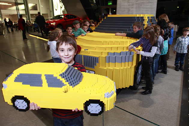 Eines der Kinder mit einem kleinen Lego-X1 am groen Lego-X1